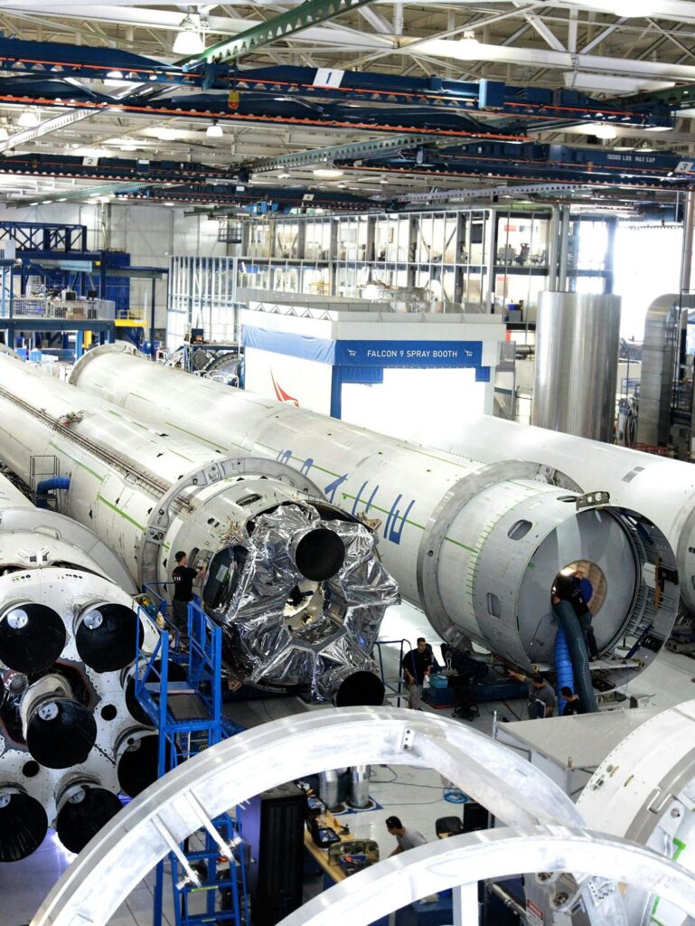 View of a spacecraft assembly line with rockets in a spacious hangar.